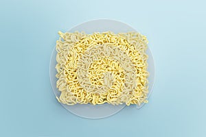 Instant noodles, raw briquette on bright blue background color.