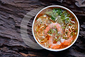 Instant noodles with shrimp on a wooden background
