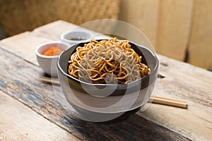 Instant noodles in white black on wood background