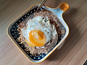 instantly fried noddle with a fried egg with wooden background photo