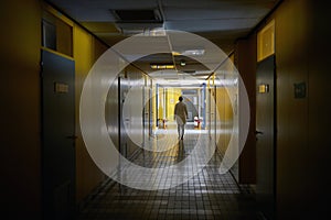 An institution employee walking a hallway. Institution, hallway, university