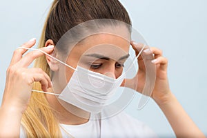 Instruction, how to put on the medical protective mask. Girl wears medical mask. Step 2
