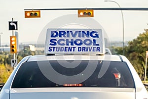 An instructional vehicle, bearing a prominent driving school student driver sign