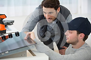 instructor and apprentice looking at appliance