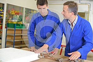 Instructor and apprentice looking at radiator