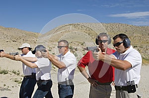 Instructor Assisting Officers At Firing Range photo