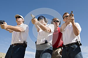 Instructor Assisting People With Guns At Firing Range