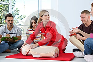 Instructor demonstrating CPR on mannequin at first aid class