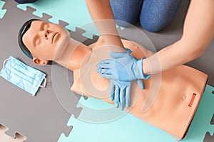 Instructor demonstrating CPR on mannequin at first aid training course