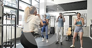 Instructor giving a boxing class to people in a gym