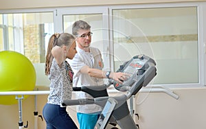 Instructor in gym with little girl