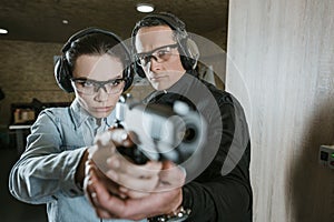 instructor helping customer holding gun