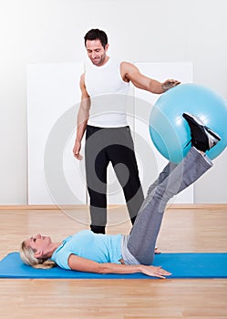 Instructor helping a woman with pilates exercises