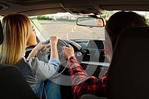 Instructor helps woman to drive the car