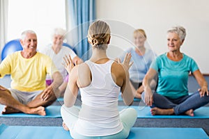 Instructor performing yoga with seniors