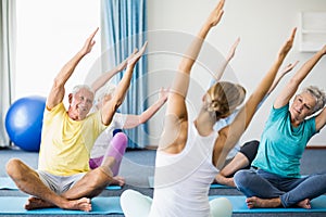 Instructor performing yoga with seniors