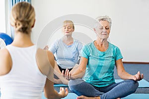 Instructor performing yoga with seniors