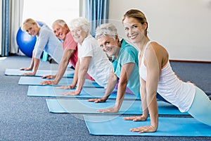 Instructor performing yoga with seniors