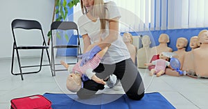 Instructor performs CPR on baby training doll. Woman instructor show how to do CPR on a doll dummy for cardiopulmonary