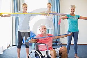 Instructor and seniors exercising with stretching bands