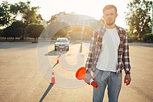 Instructor sets the cone, driving school concept