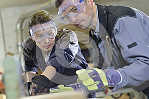 Instructor showing trainee carpentry work photo