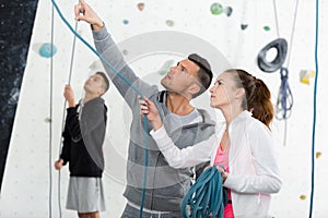 Instructor showing young climbers ropes at indoor wall