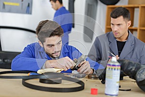 Instructor with student in repairshop changing motor oil