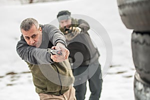 Instructor teaches student tactical gun shooting behind cover or barricade