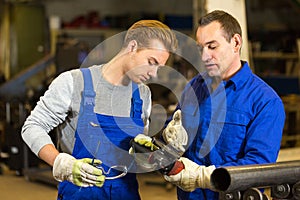 Instructor teaches trainee how to use an angle grinder