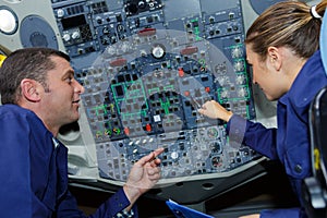 Instructor teaching female engineer cockpit