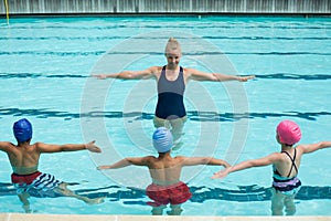 Instructor teaching students in swimming pool photo