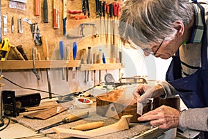 Instrument maker masking a guitar with tape