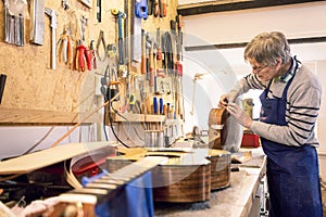 Instrument maker repairing an old acoustic guitar