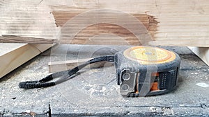 Instrument measuring tape under a layer of dust on a table in a workshop