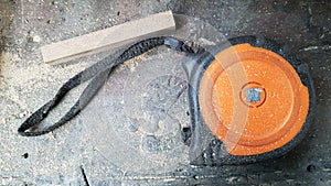 Instrument measuring tape under a layer of dust on a table in a workshop