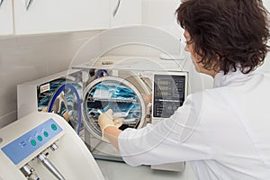 Instrument sterilization in dentistry, nurse loading instrumenst in sterilizer.