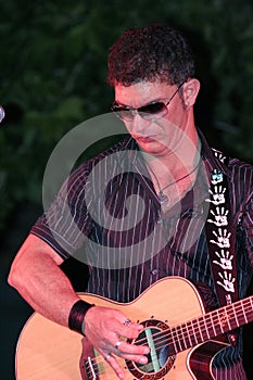 Instrumentalist plays the guitar in front of the spectators.