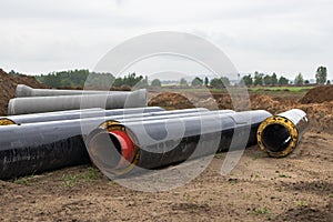 Insulated pipe. Large metal pipes with a plastic sheath laid in a trench. Modern pipeline for supplying hot water and heating to a