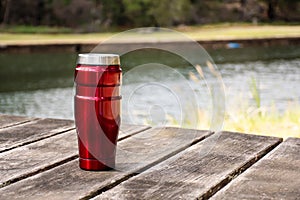 Insulated reusable stainless steel coffee travel tumbler mug on the table with nature background