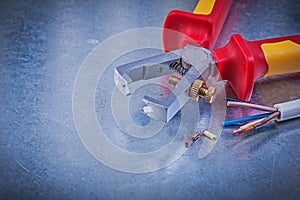 Insulated strippers electrical wires on scratched metallic backg