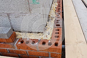 Insulating walls of new build houses by placing rock wool inside wall cavities as part of the energy-saving measures close-up.