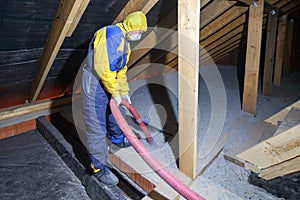 Insulation of the attic with cellulose insulation. Spraying from a hose photo