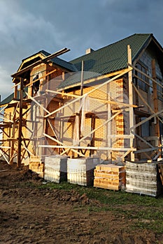 Insulation of the house with facade bricks, construction of a new house and scaffolding near the walls