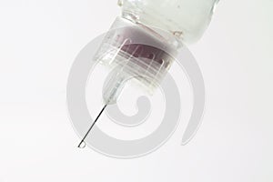 Insulin drips from needle on syringe on white