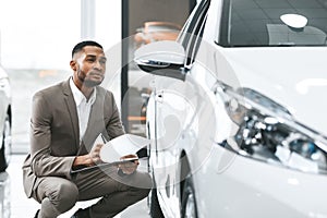 Insurance Agent Checking Car Taking Notes In Dealership Store