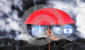 Insurance agent covering illustrations with red umbrella during storm