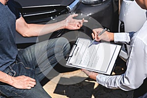 Insurance Agent and customer assessed negotiation, checking and signing on report claim form process after accident collision,