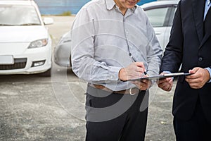 Insurance Agent examine Damaged Car and customer filing signature on Report Claim Form process after accident, Traffic Accident