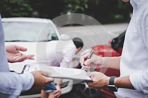 Insurance Agent examine Damaged Car and customer filing signature on Report Claim Form process after accident, Traffic Accident